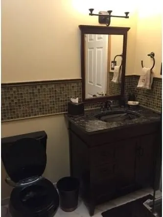 Dark granite vanity top with an undermount sink and mosaic tile band