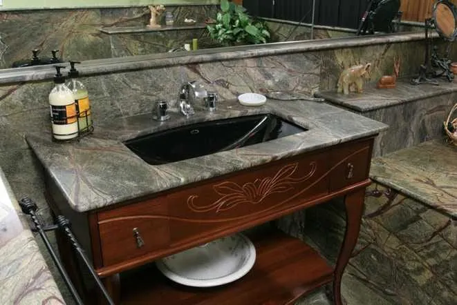 Green and brown granite vanity top on a carved wood cabinet