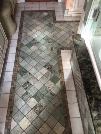 Shower lined in green-veined marble tile