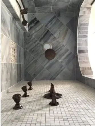 Grey marble tiled shower with a rain shower head
