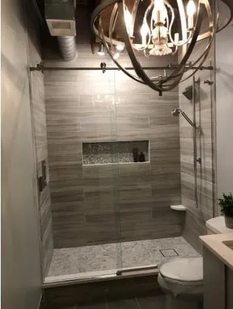 Grey tiled walk-in shower with a recessed niche