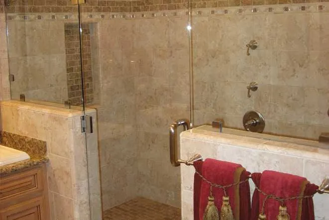 Travertine tiled shower with a frameless glass door