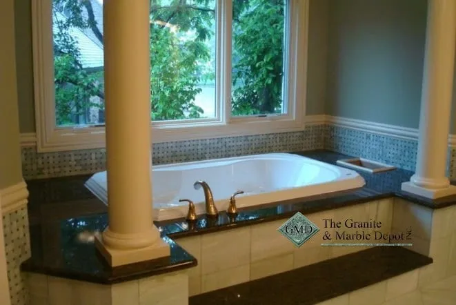 Whirlpool tub framed by columns with a blue mosaic tile surround