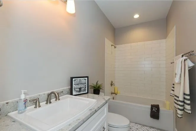 White tub with a tiled surround in a bright bathroom