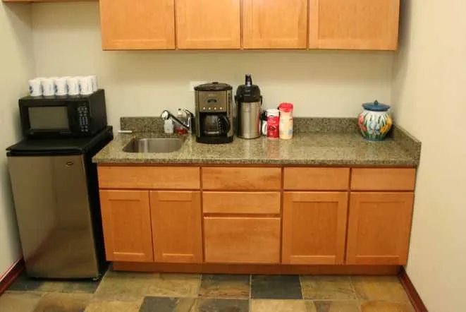 Office break room with a granite counter and undermount sink
