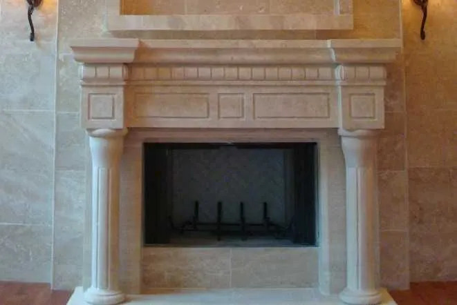 Cast stone fireplace mantel with fluted columns and a raised hearth
