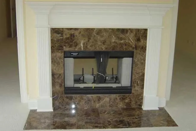 Dark marble fireplace surround and hearth under a white painted mantel