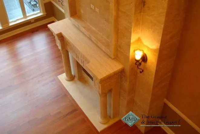 Travertine hearth and mantel detail beside a wall sconce