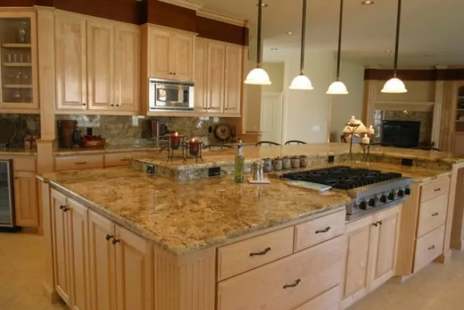 Gold-toned granite island with a built-in cooktop and cream cabinetry