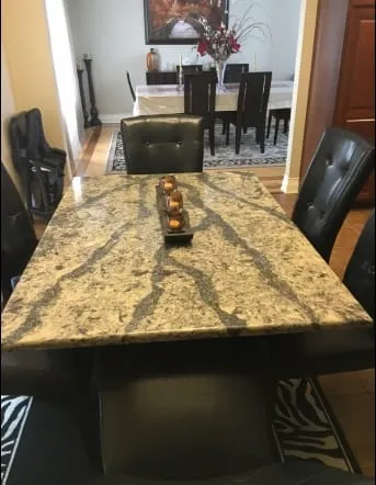 Gold and brown granite island with dining seating alongside