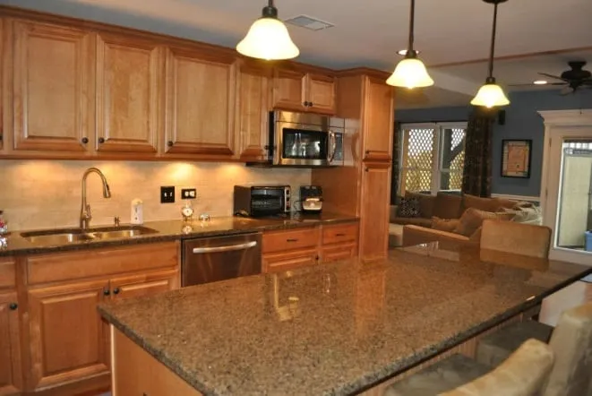 Maple cabinets with granite countertops and an undermount sink below a window