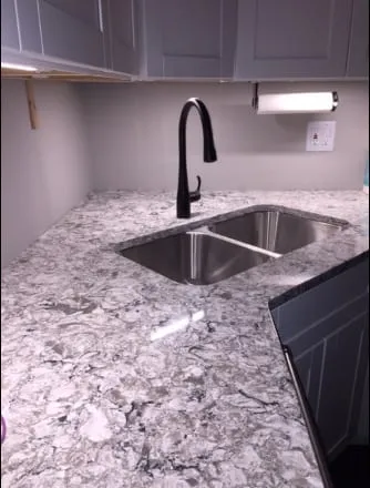 Grey and white granite countertop with a corner undermount sink