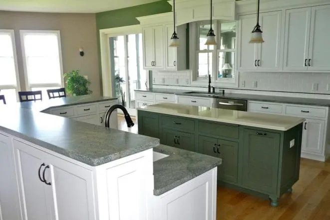 Grey granite island with sage green base cabinets and white perimeter cabinetry