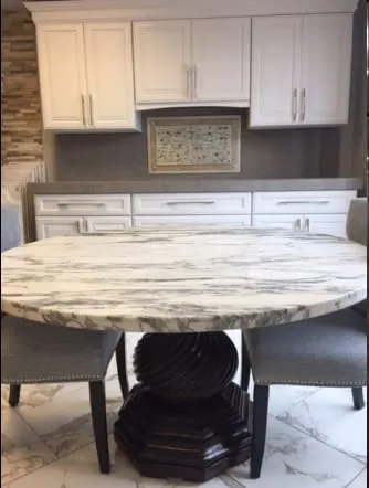 Round white granite table top with grey veining on a pedestal base