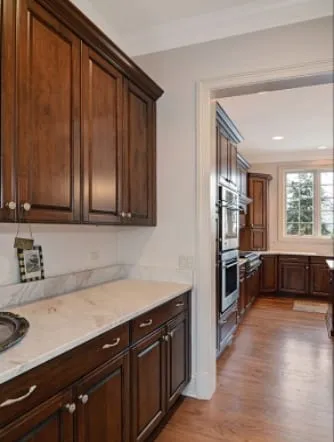 White stone countertops against dark wood cabinets