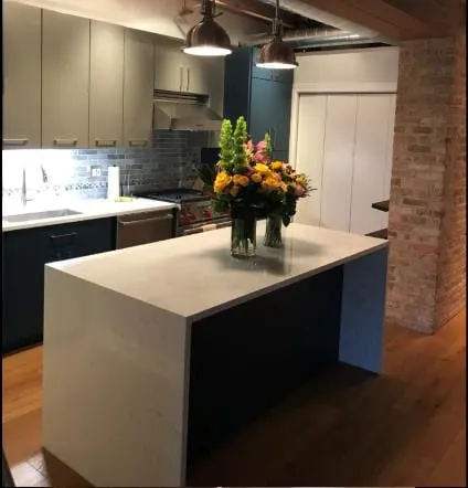 White quartz island with a waterfall end against an exposed brick wall