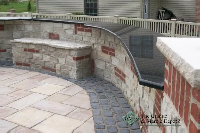 Curved brick and stone bar with a capped counter on a paver patio